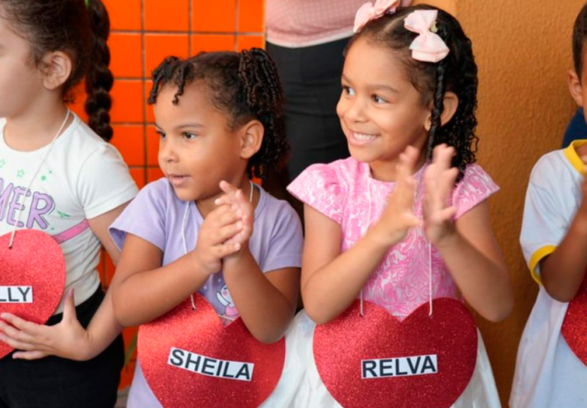 Corredor emocionante: crianças recebem mães com música e plaquinhas.